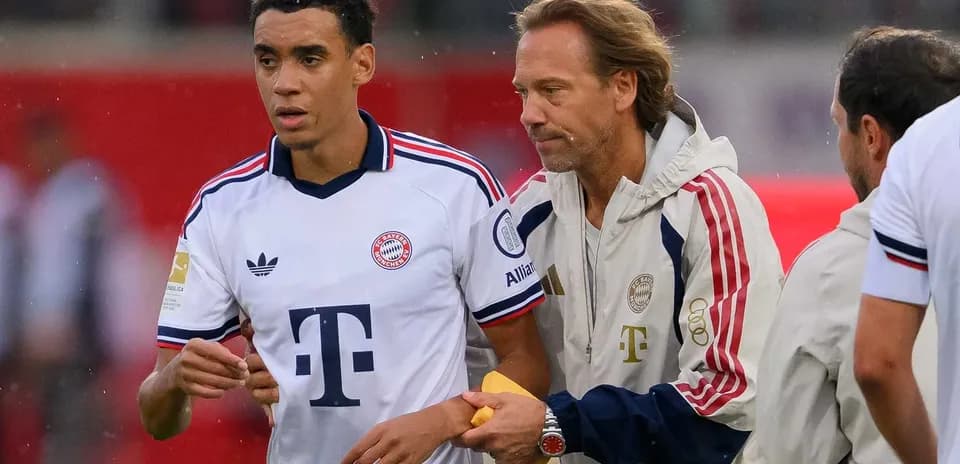 Bayern Munich player interacting with coach on sideline