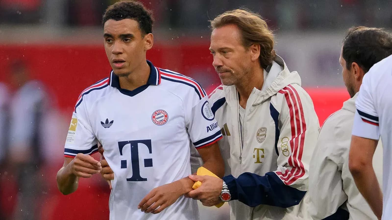 Bayern Munich player interacting with coach on sideline