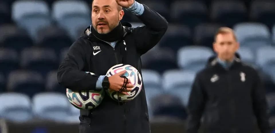 Coach giving instructions while holding footballs