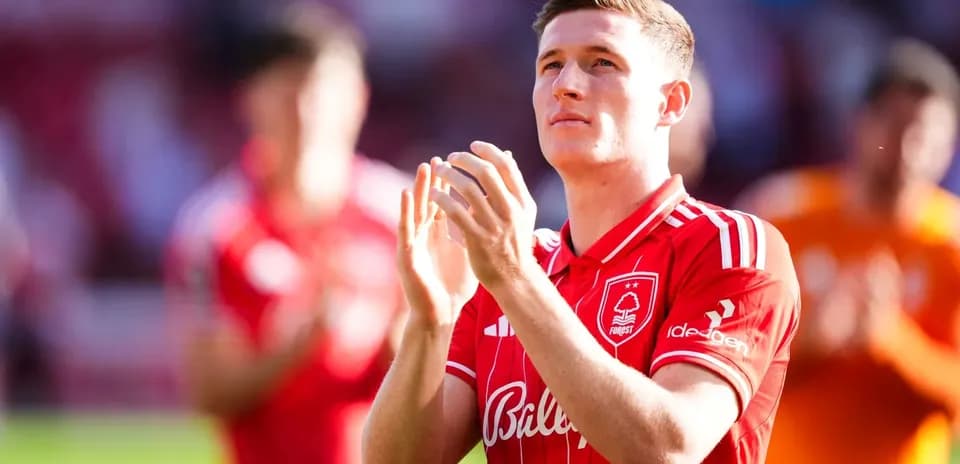 Player applauding fans while wearing red jersey