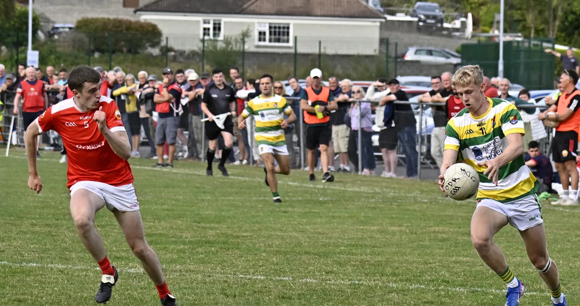 Player in yellow and green passing ball during match