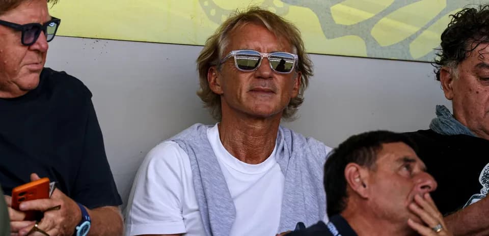 Man with sunglasses sitting among spectators
