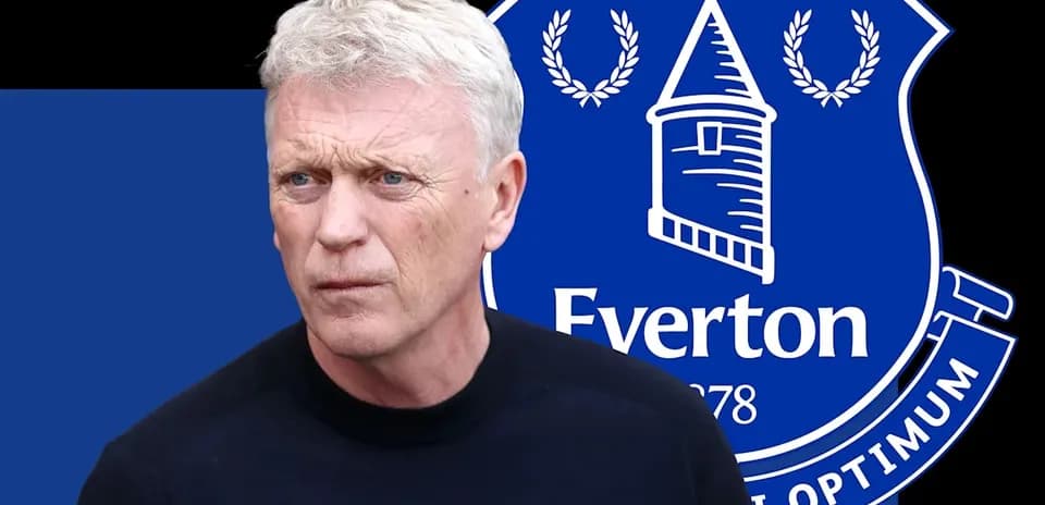 Man standing in front of Everton FC logo