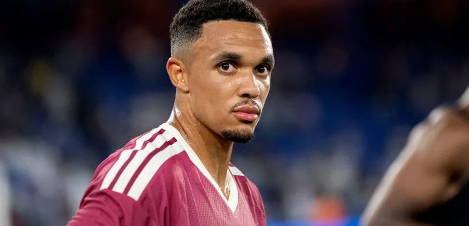 Football player in maroon kit looking towards camera