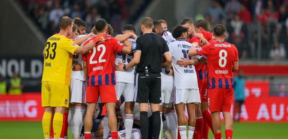 Players from both teams huddled together on the pitch