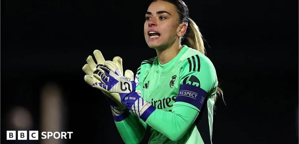 Goalkeeper in green uniform directing teammates on field