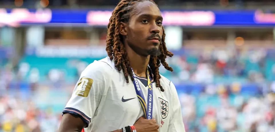 Player wearing England jersey with medal on field