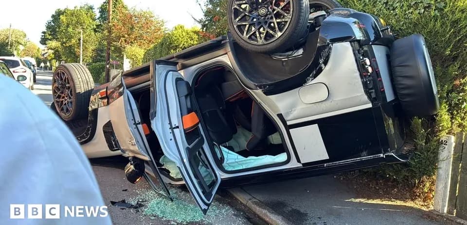 Upside-down car on roadside with shattered glass