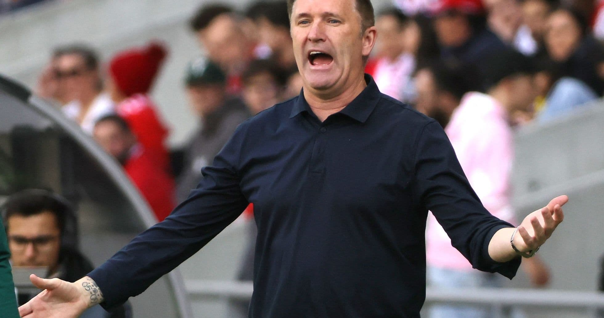 Coach gesturing passionately during match on sidelines