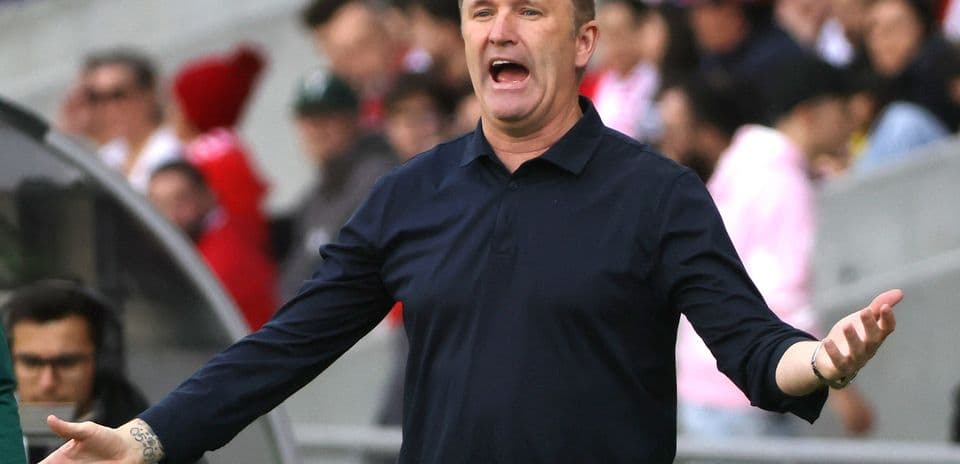 Coach gesturing passionately during match on sidelines