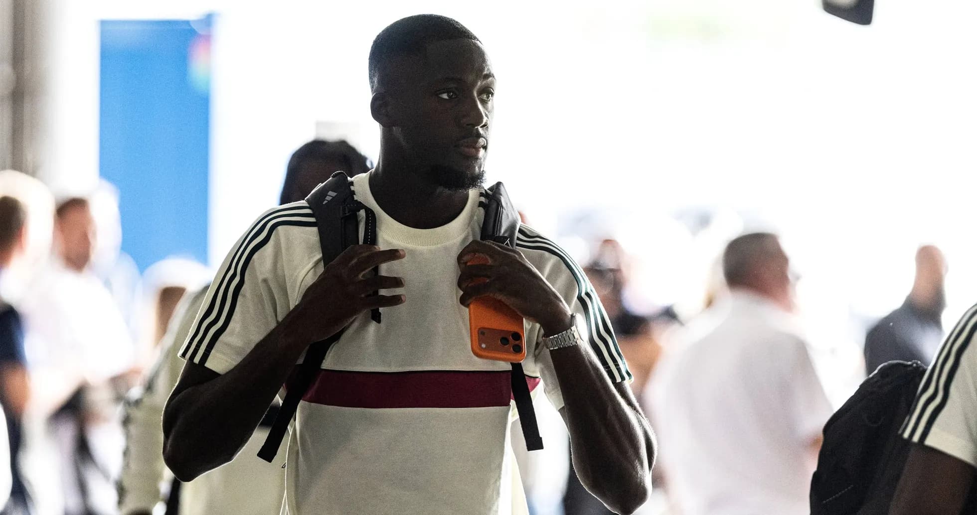Player entering venue with backpack and phone