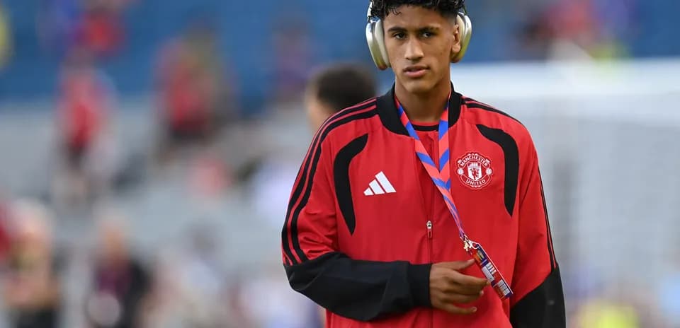 Player wearing headphones and Manchester United tracksuit