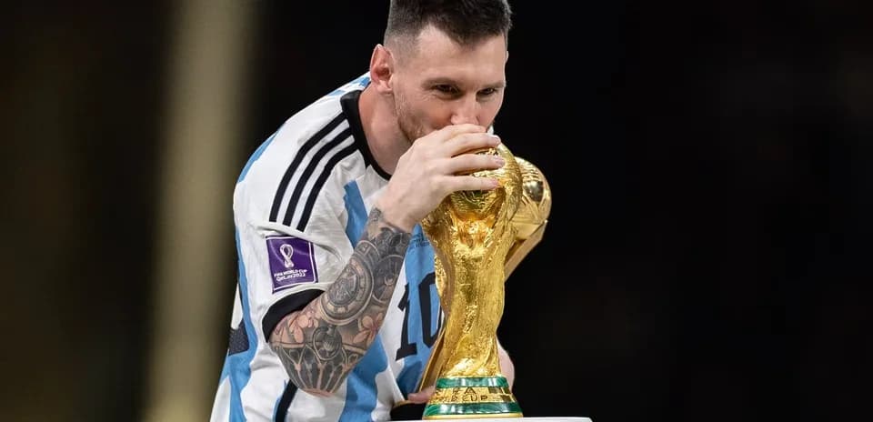 Player kissing FIFA World Cup trophy on podium