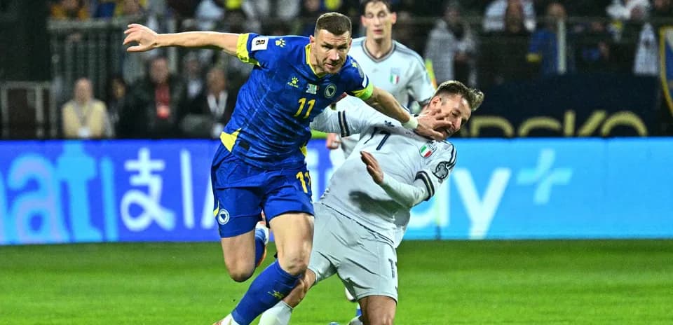 Player from Bosnia challenging Italian defender during match