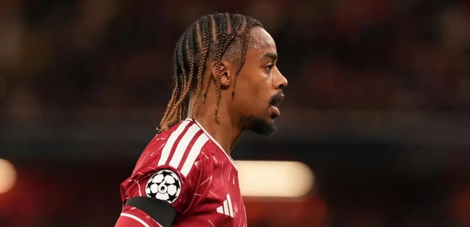 Player in red jersey during match with UEFA badge