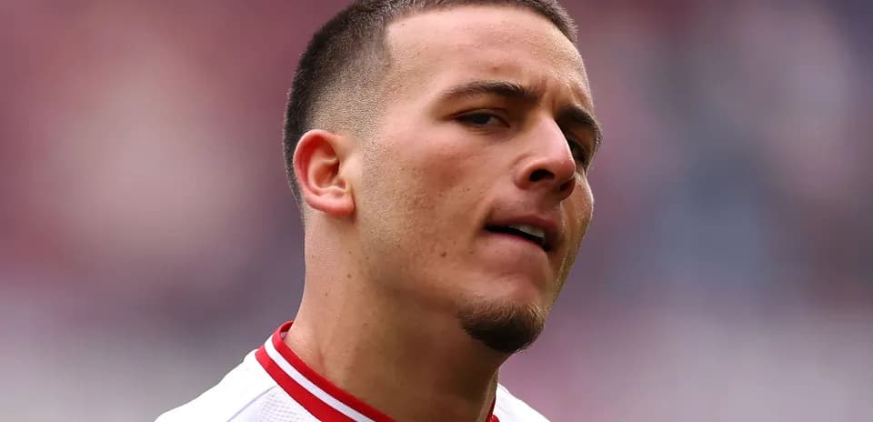 Player in white jersey with red collar on field