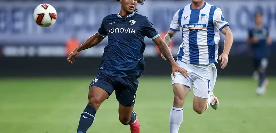 Player dribbling ball with opponent chasing during match