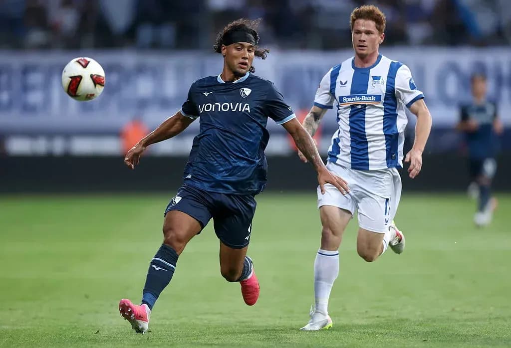 Player dribbling ball with opponent chasing during match