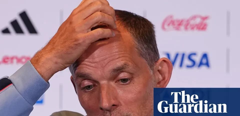Coach speaking at press conference with hand on head