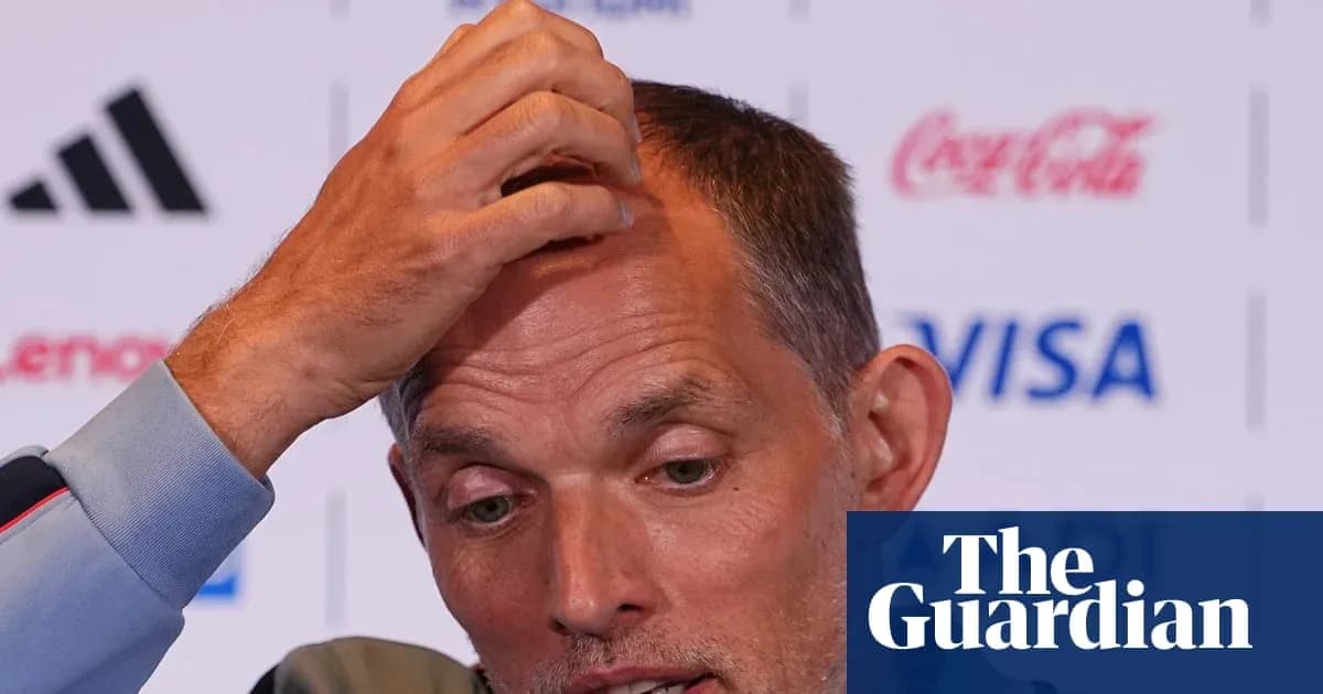 Coach speaking at press conference with hand on head