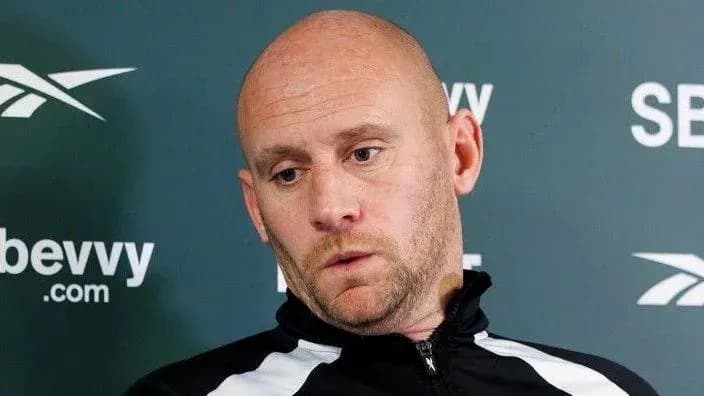 Man in sports jacket during press conference