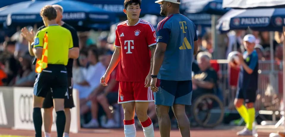 Bayern Munich player talking to coach on sideline