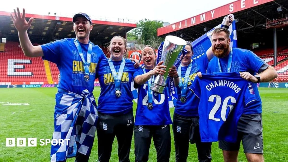 Celebrating team holding trophy and banners on pitch