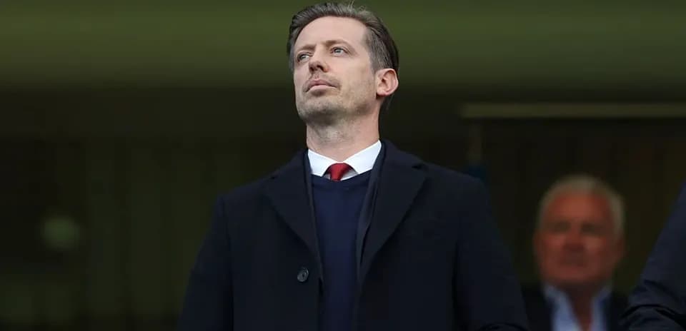 Man in suit observing from a stadium box