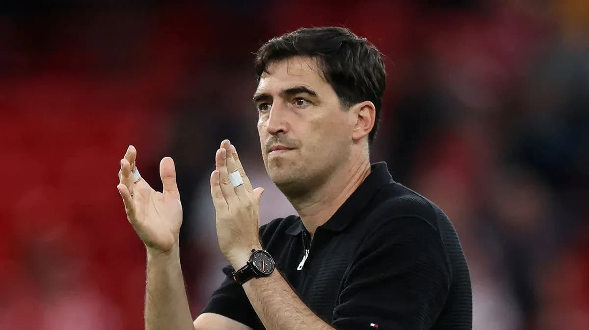 Coach applauding fans in stadium after match