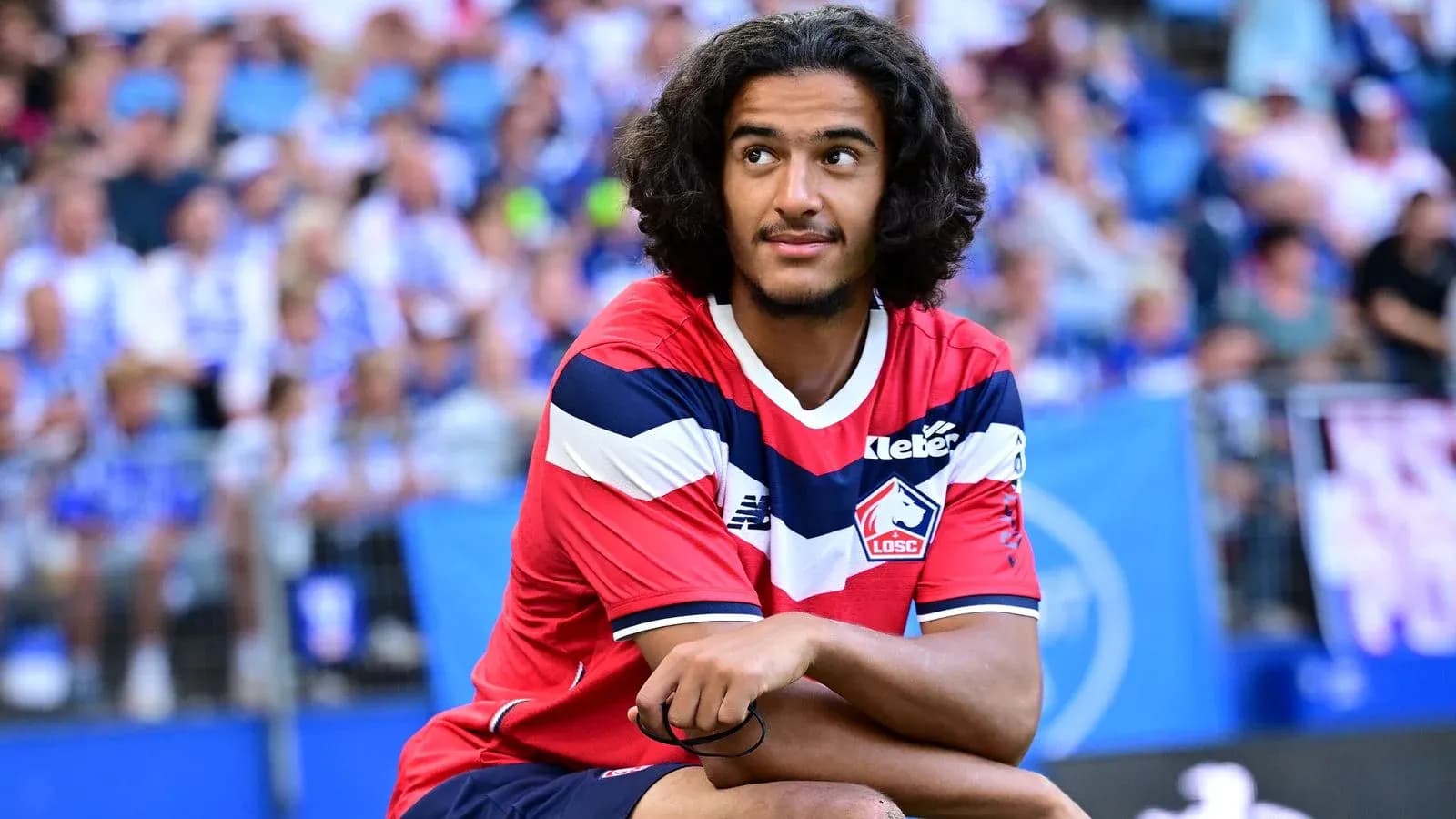 Player sitting on the pitch during match warm-up