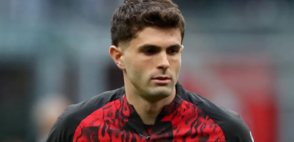 Player walking on the field in AC Milan jersey