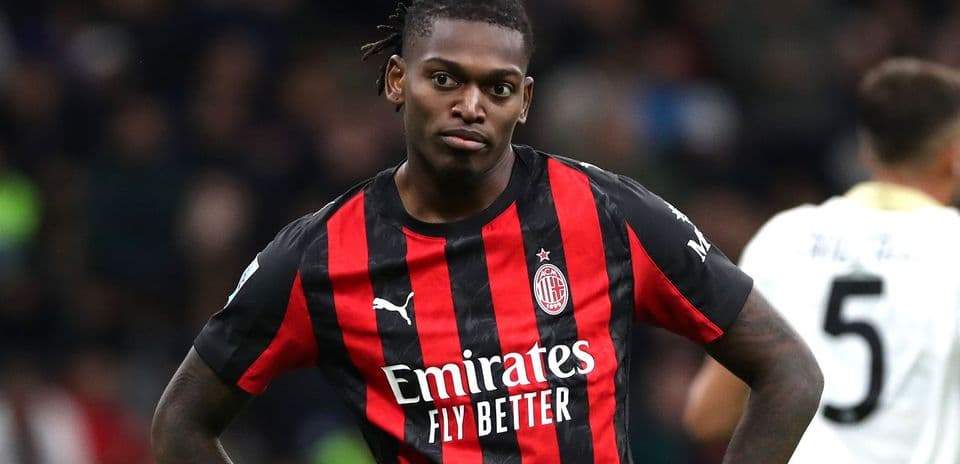 AC Milan player in red and black jersey on field