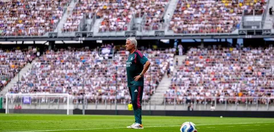 Coach observing match in front of packed stadium