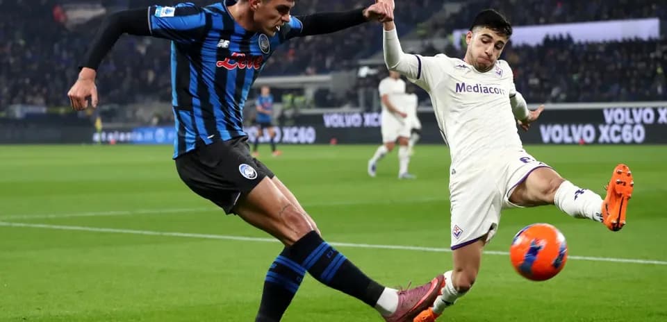 Fiorentina player challenging Atalanta opponent for the ball