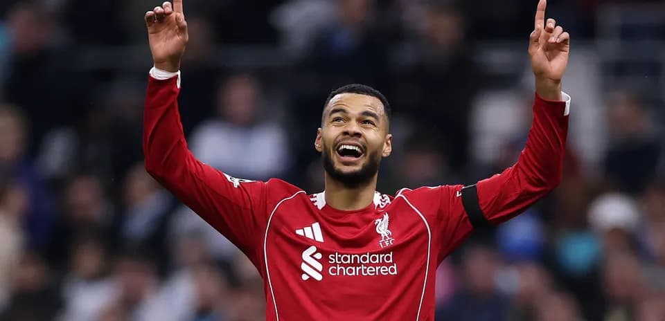 Player celebrating with raised arms in red jersey