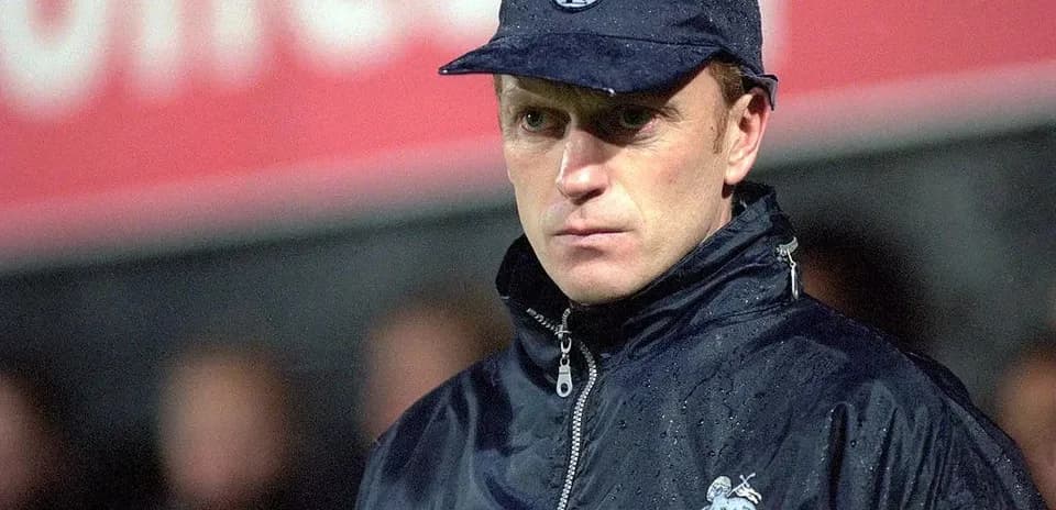 Coach observing the match in rainy conditions