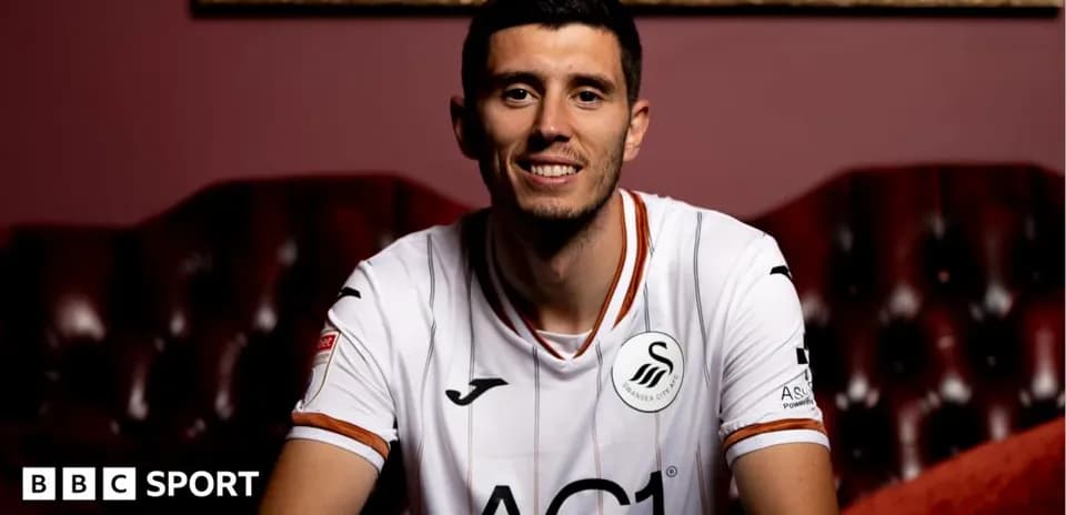 Player smiling in Swansea City jersey indoors