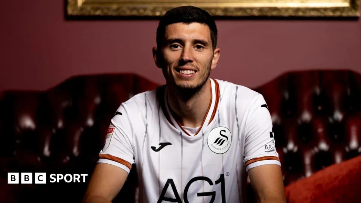 Player smiling in Swansea City jersey indoors