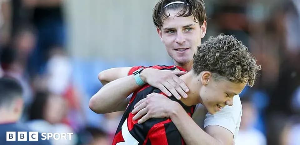 Two players embracing on the pitch after match