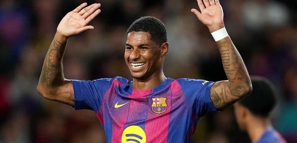 Player celebrating with raised hands in Barcelona kit
