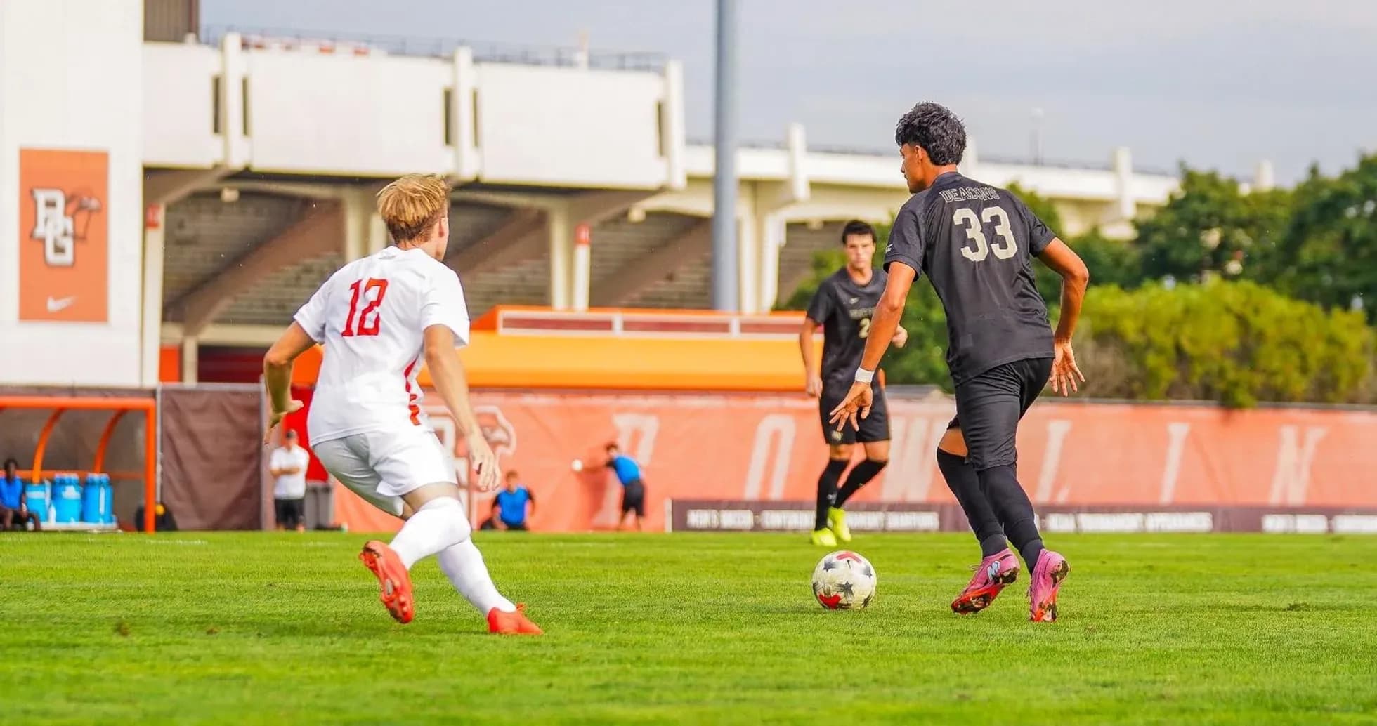 Player in white chasing ball held by player in black