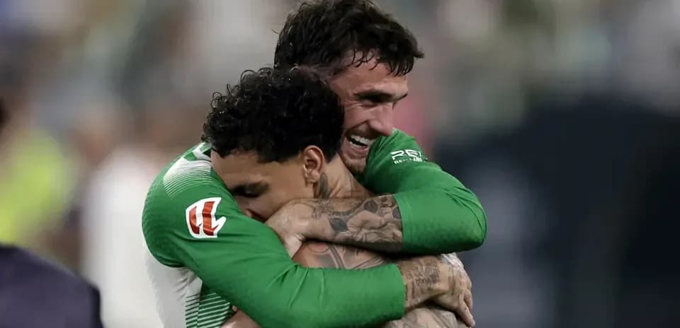 Two players celebrating with a hug on the field