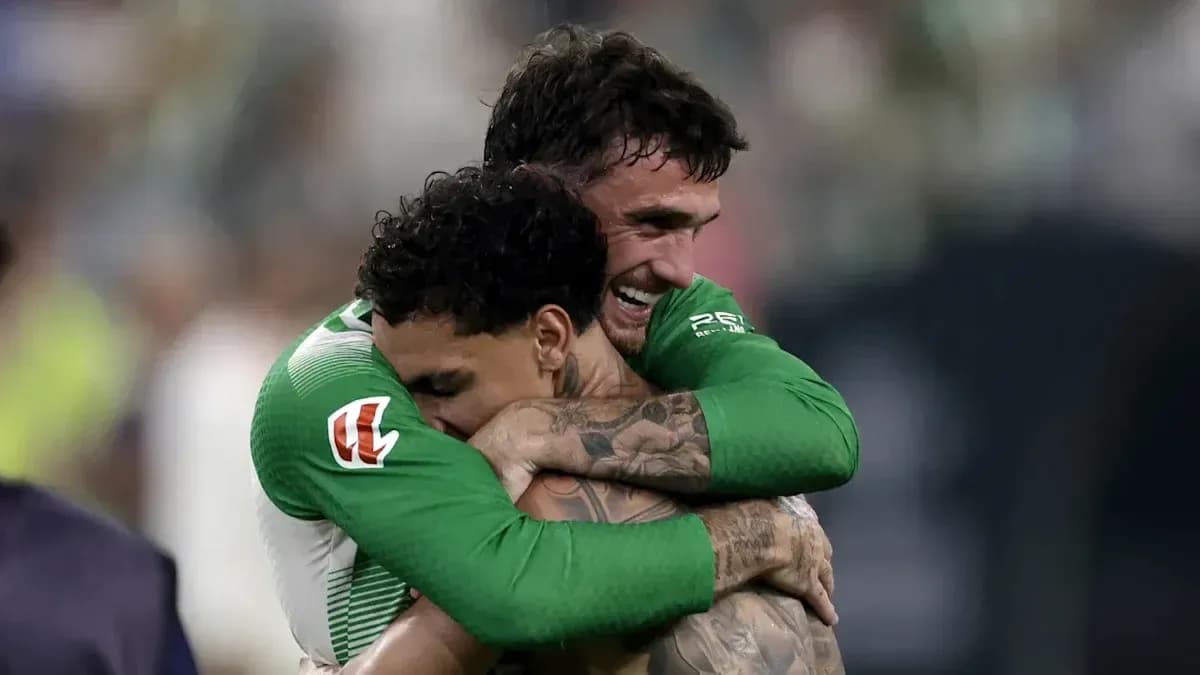 Two players celebrating with a hug on the field