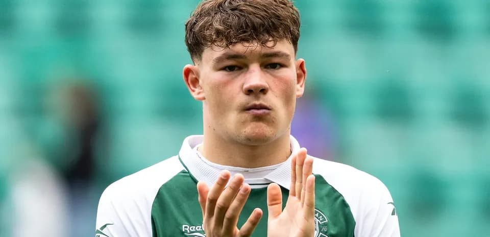 Player applauding in Hibernian FC kit on pitch