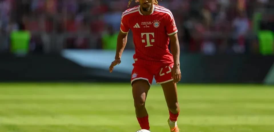 Player in Bayern Munich kit dribbling ball on field