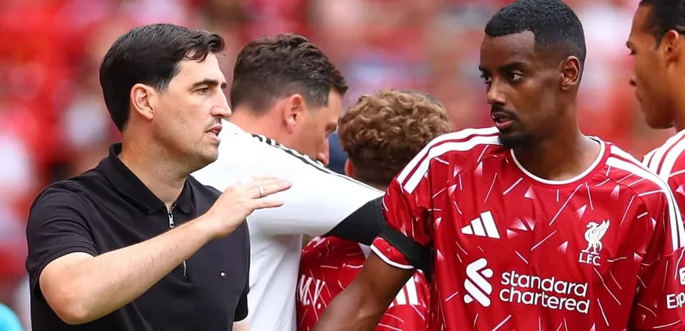 Coach discussing strategy with Liverpool player on sidelines