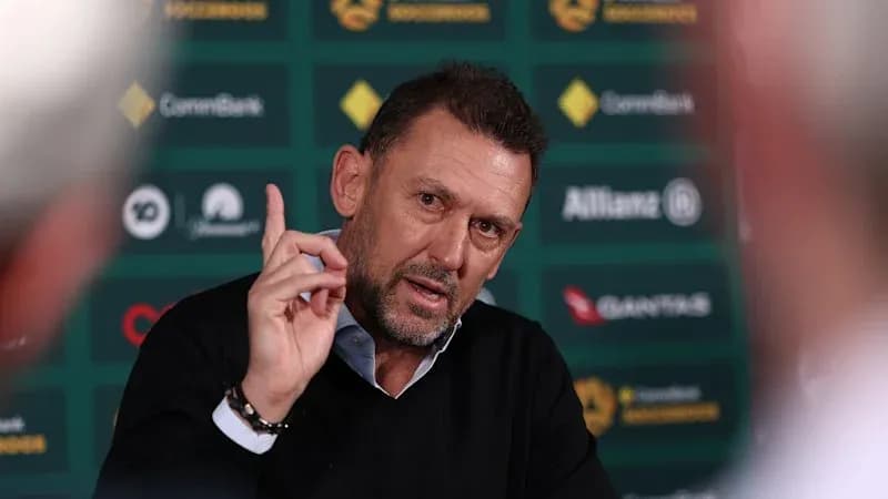 Coach speaking during press conference with hand raised