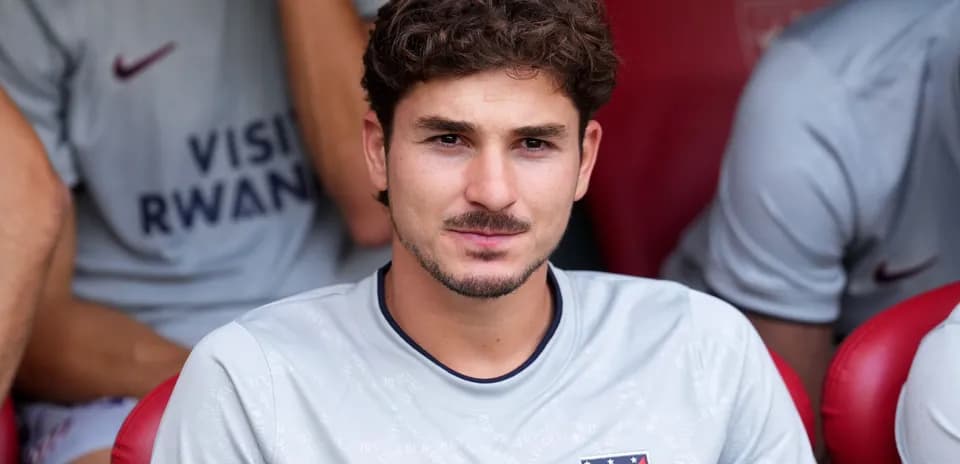 Player seated on bench wearing Atlético Madrid kit