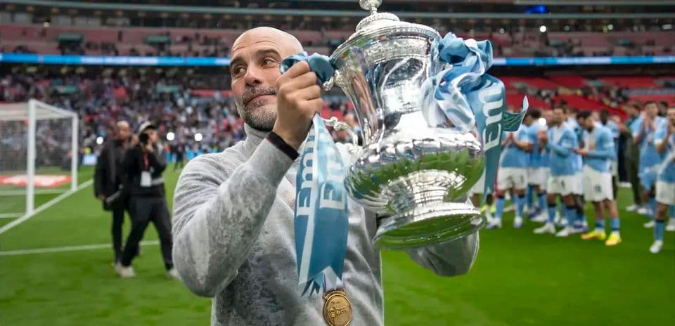 Manager holding trophy at Wembley Stadium celebration