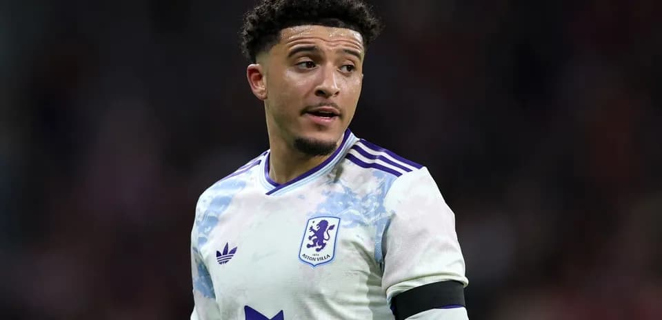 Aston Villa player wearing team jersey on pitch